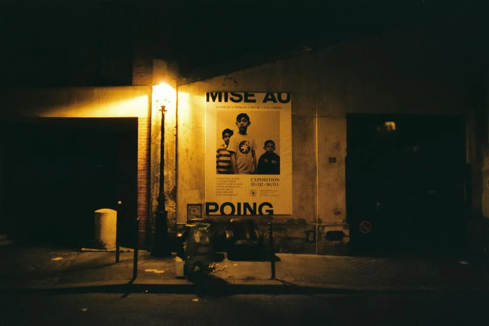 Museum poster lit by a streetlamp at night